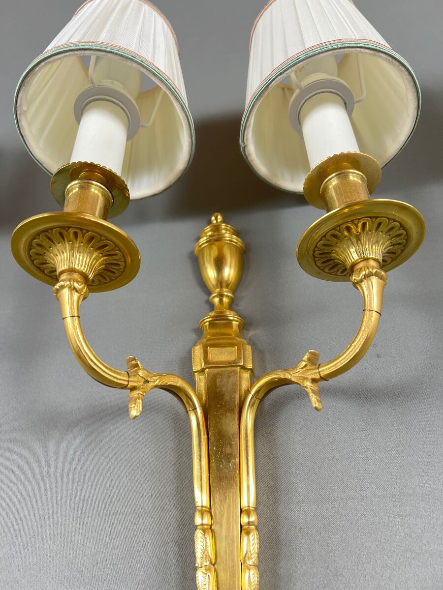 Set of three Louis XVI style wall sconces in gilded bronze, 20th century.