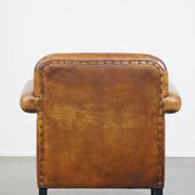 Sheepskin Art Deco design armchair with sleek finish and black piping