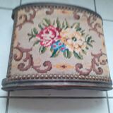 Antique carved stool in an arched shape covered in handmade tapestry