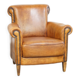 Comfortable, cozy armchair made of sheepskin leather with a neat finish and decorative nailhead trim