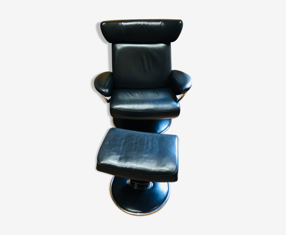 Black leather armchair stressless model jazz and its footrest