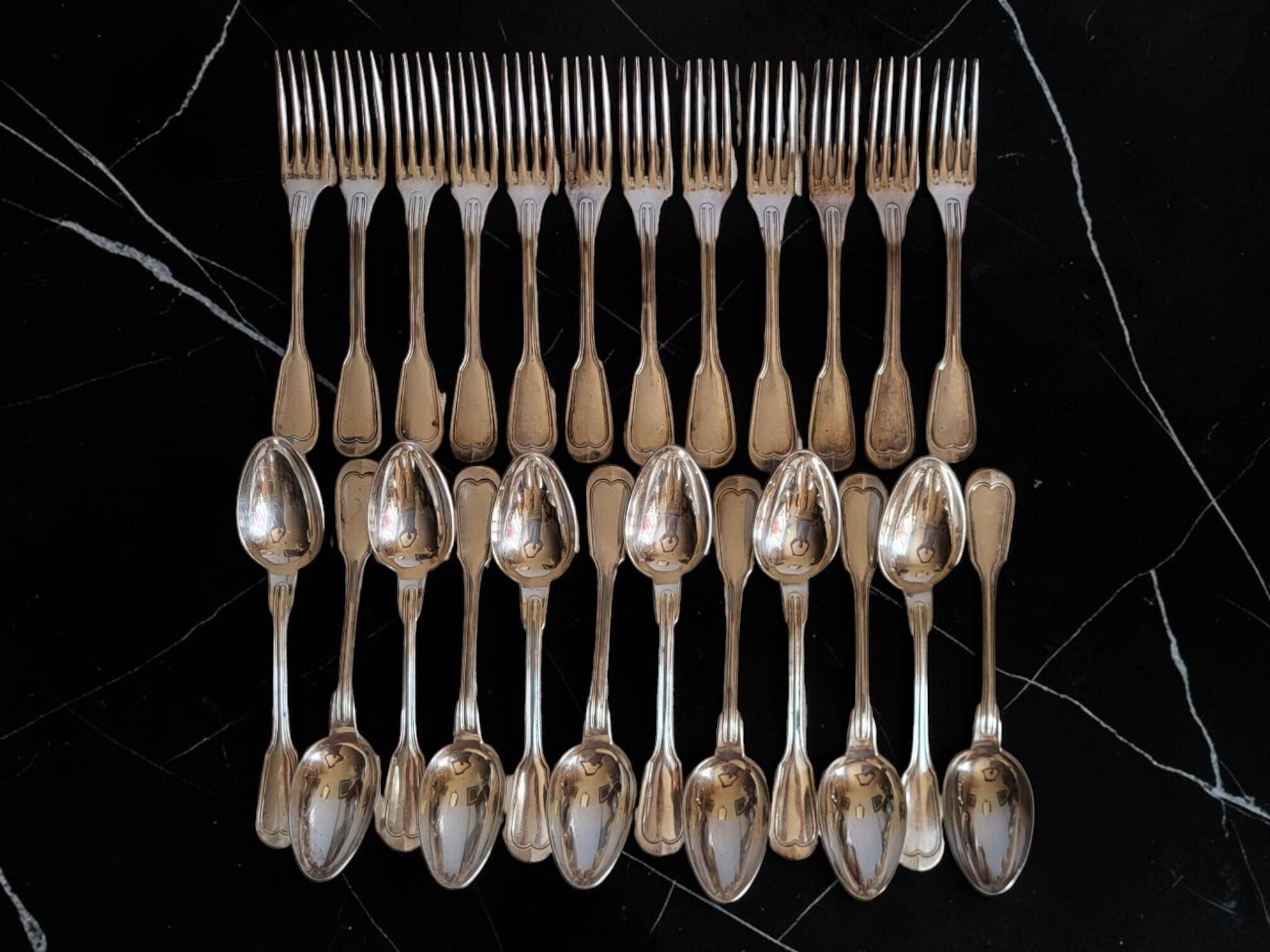 24 silver-plated metal table settings in the filet model.