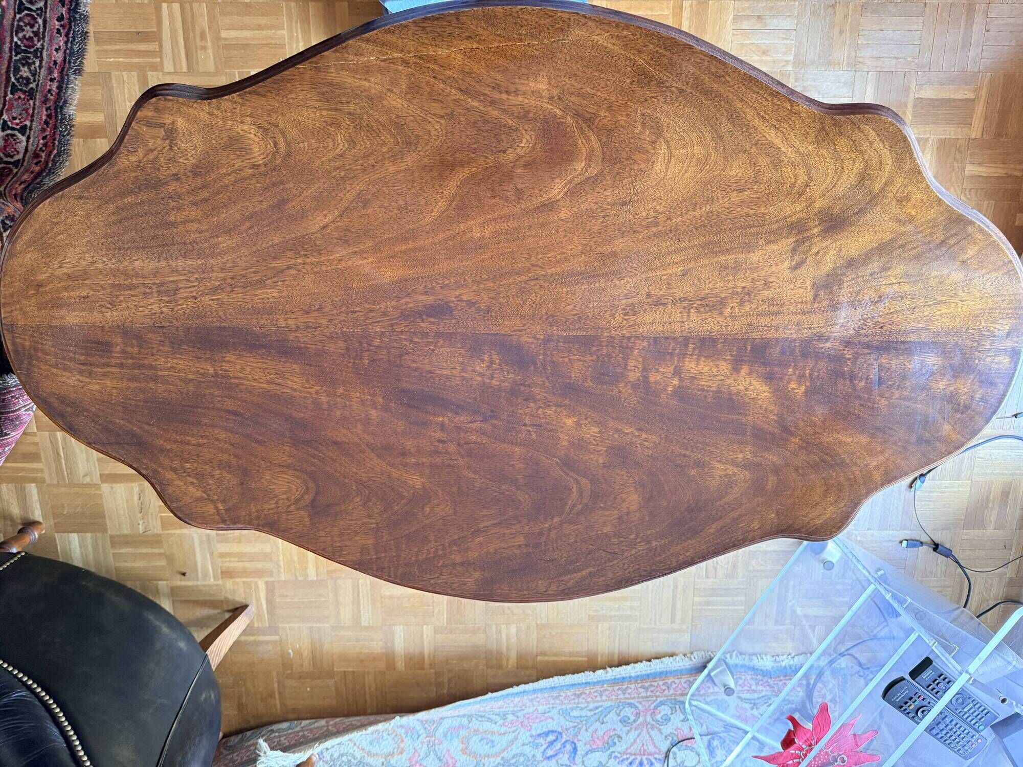 Antique mahogany table with a scalloped top and a sculpted central leg.