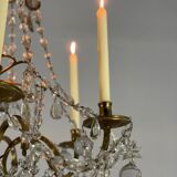 Golden bronze chandelier trimmed with drop-shaped grapevines