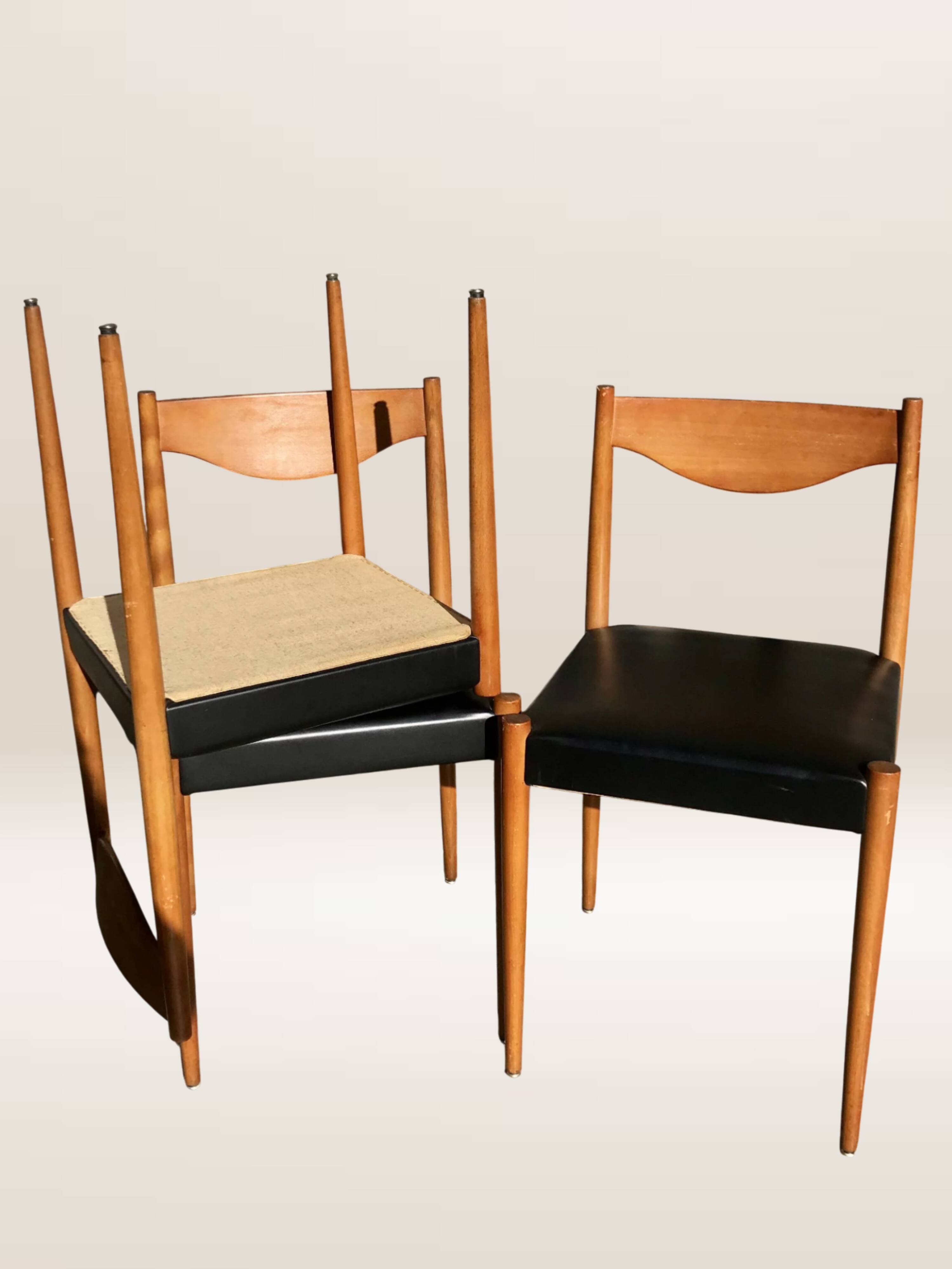 Set of 6 modernist chairs with black faux leather seats.