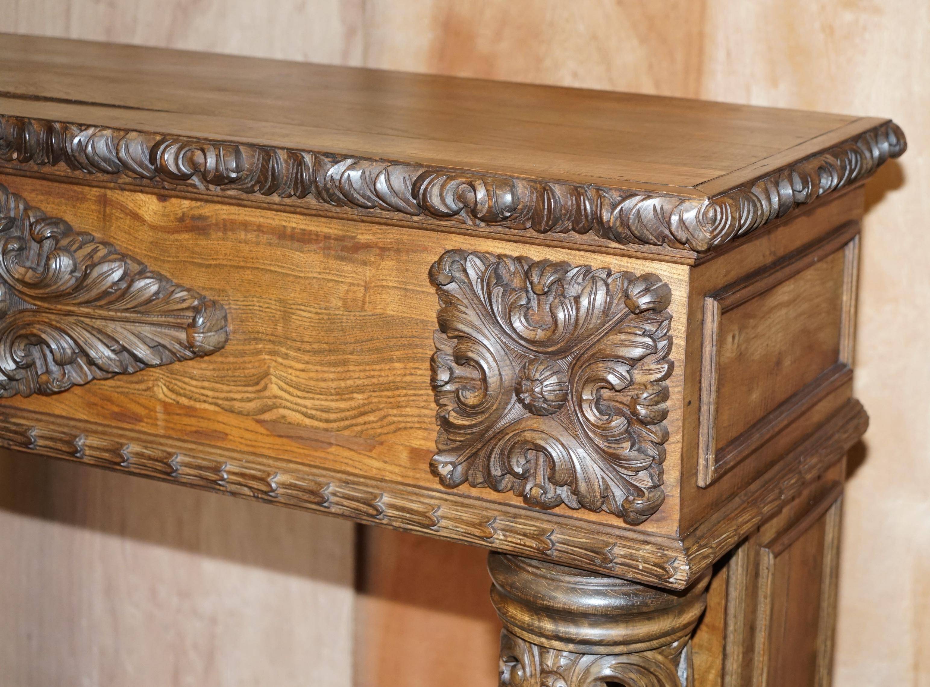 Antique fireplace from around 1880 in solid hand-carved elm with openwork columns.