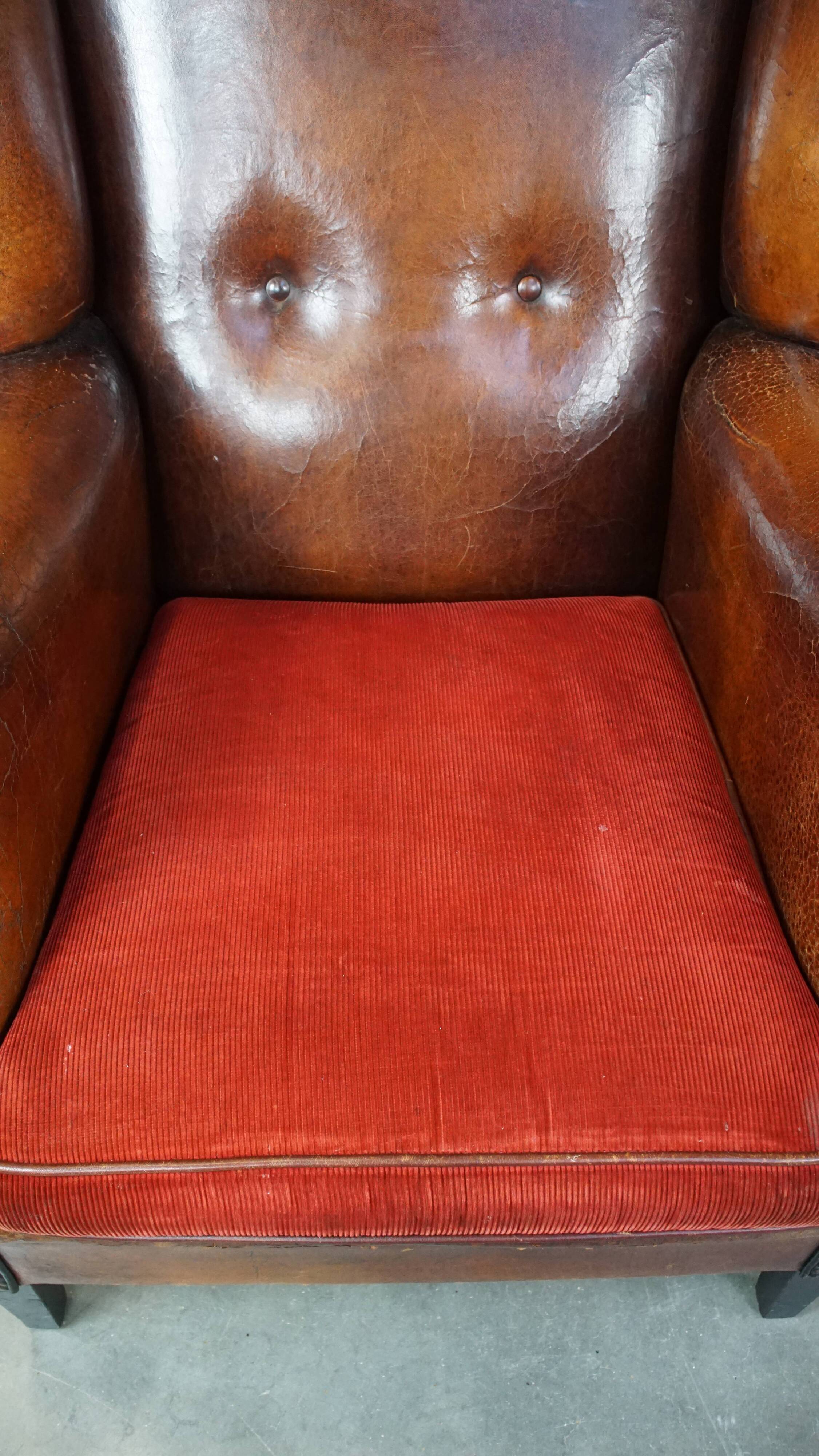 Set of 2 sheep leather wingback chairs with red corduroy seat cushions