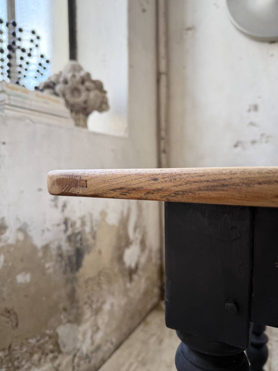 Oak farmhouse table with turned black legs.