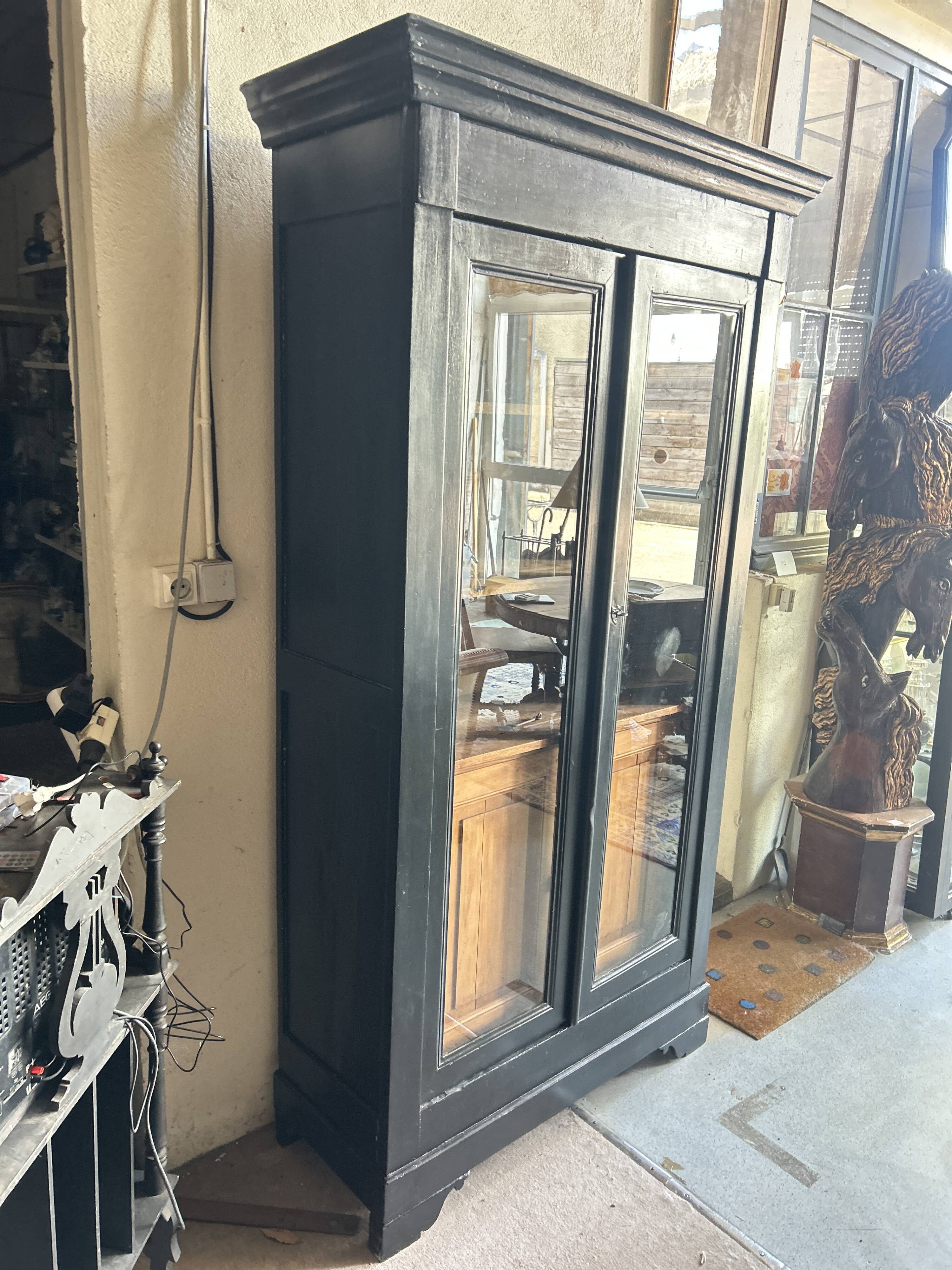 Black painted wardrobe with two glass doors and an interior sideboard.