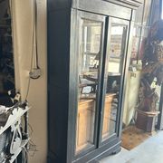 Black painted wardrobe with two glass doors and an interior sideboard.
