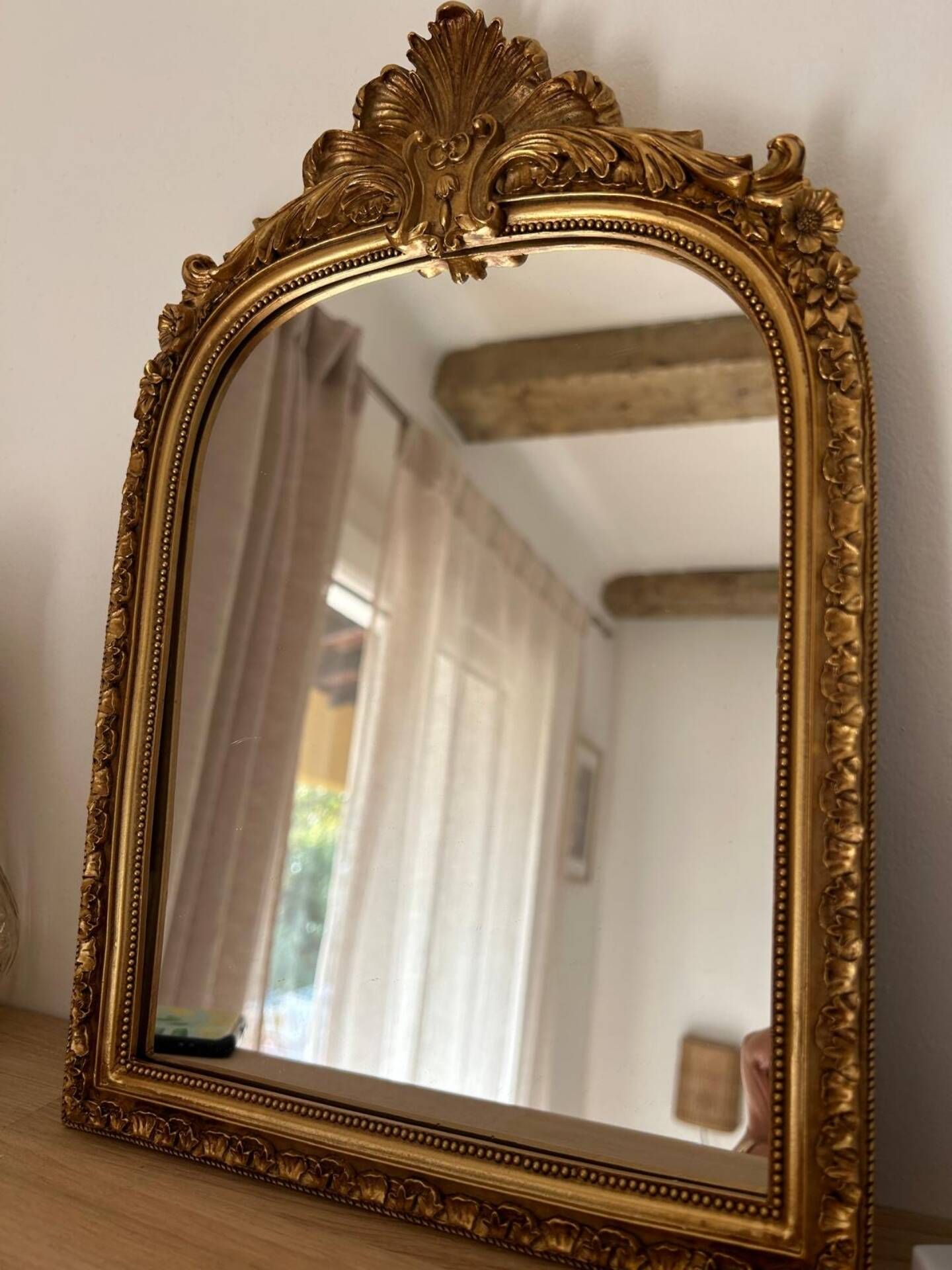 Miroir décoratif avec moulures et fronton.