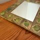 Vintage 1960s green and brown glazed ceramic mirror.