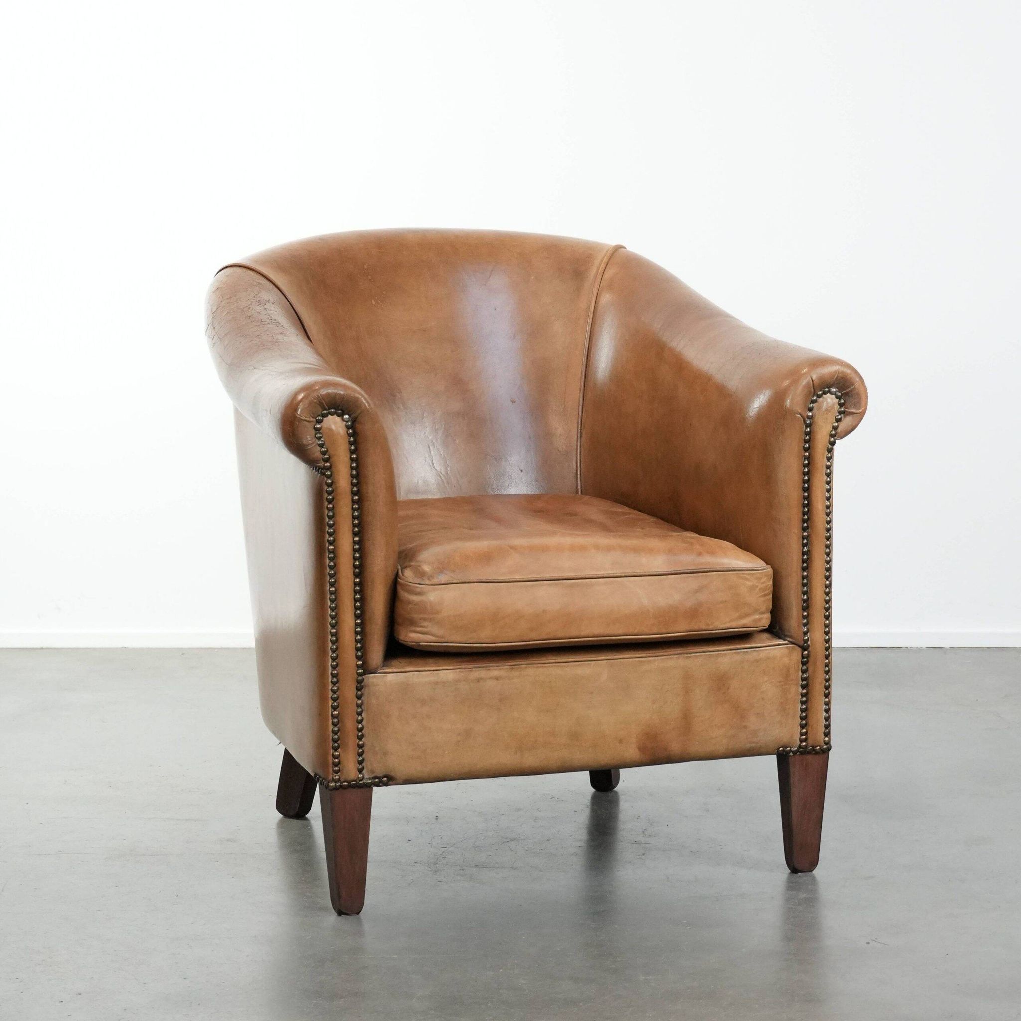 Characterful club chair made of sheepskin leather with light cognac colours
