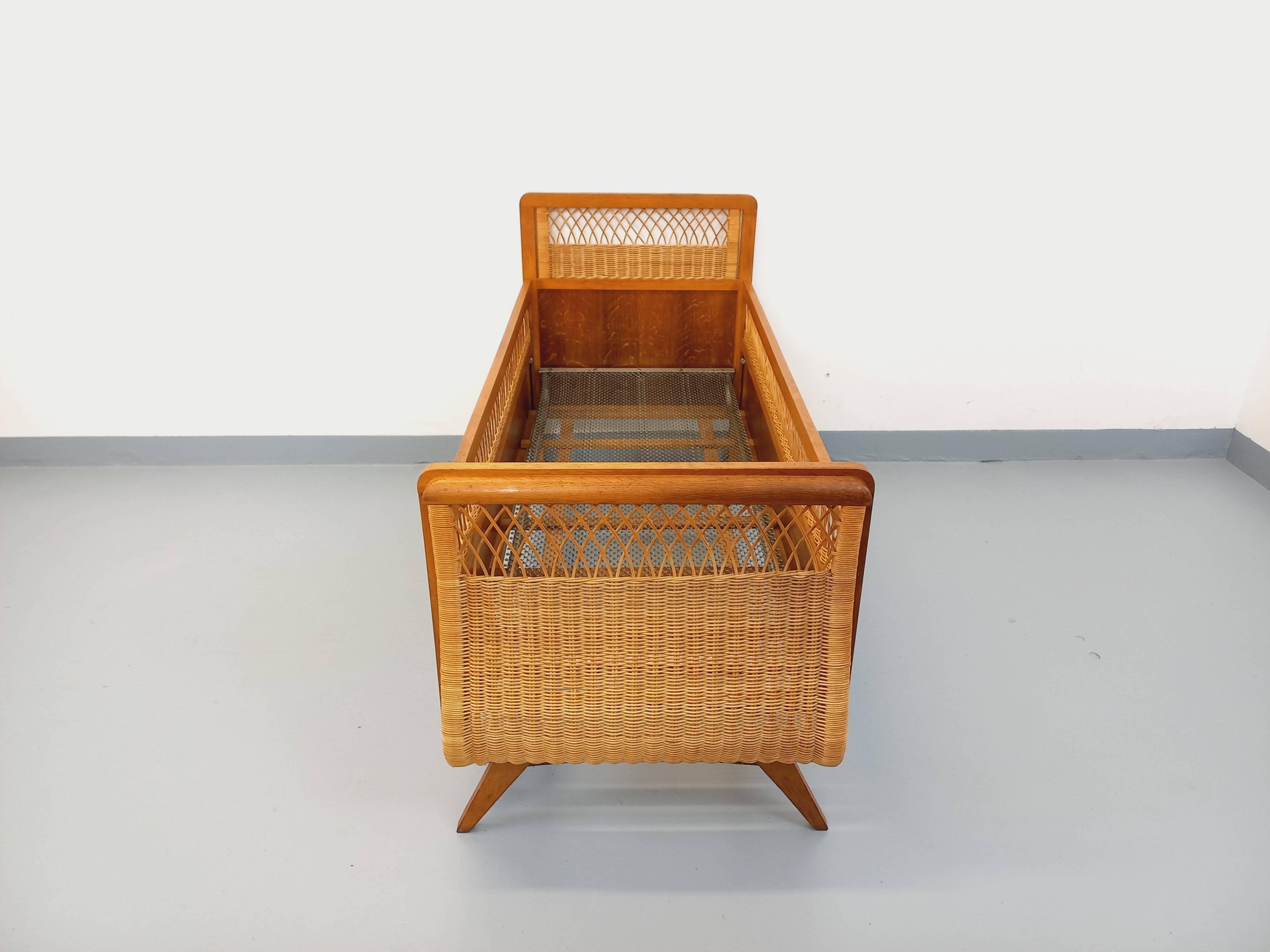 Vintage oak and rattan baby cot from the 1960s.