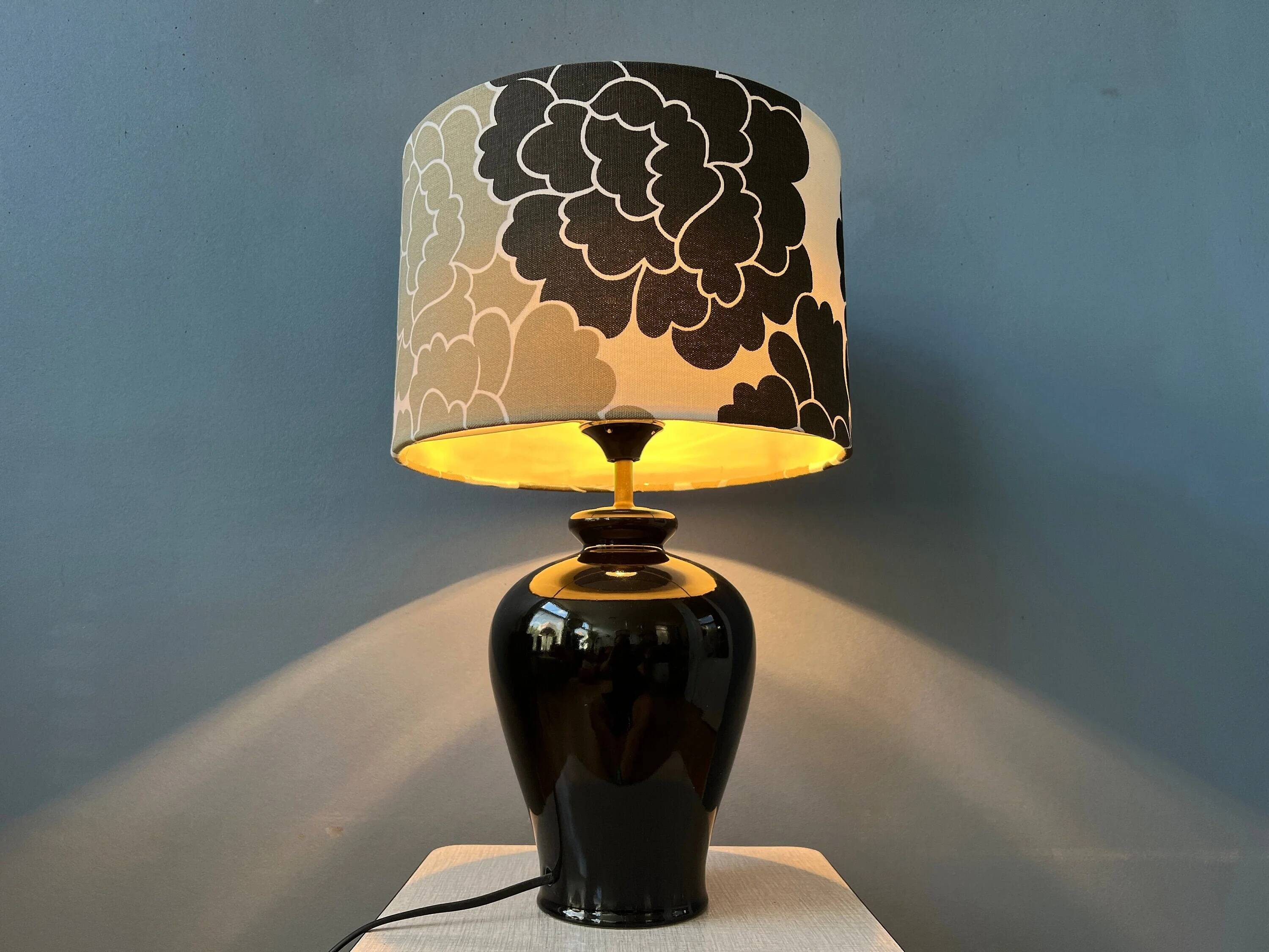 Small Space Age table lamp with a porcelain base and black and white flower shade.