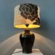 Small Space Age table lamp with a porcelain base and black and white flower shade.