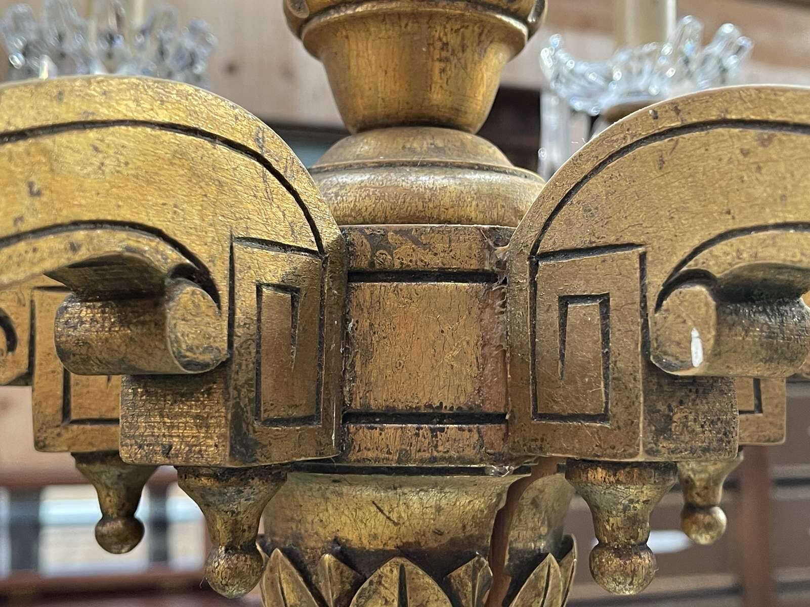 Golden wooden chandelier with crystal pendants from the 19th century.