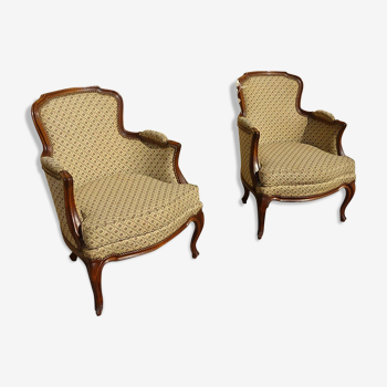 Paire de fauteuils bergère en noyer et tissu tapissier