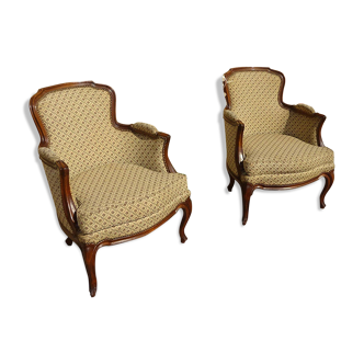 Paire de fauteuils bergère en noyer et tissu tapissier