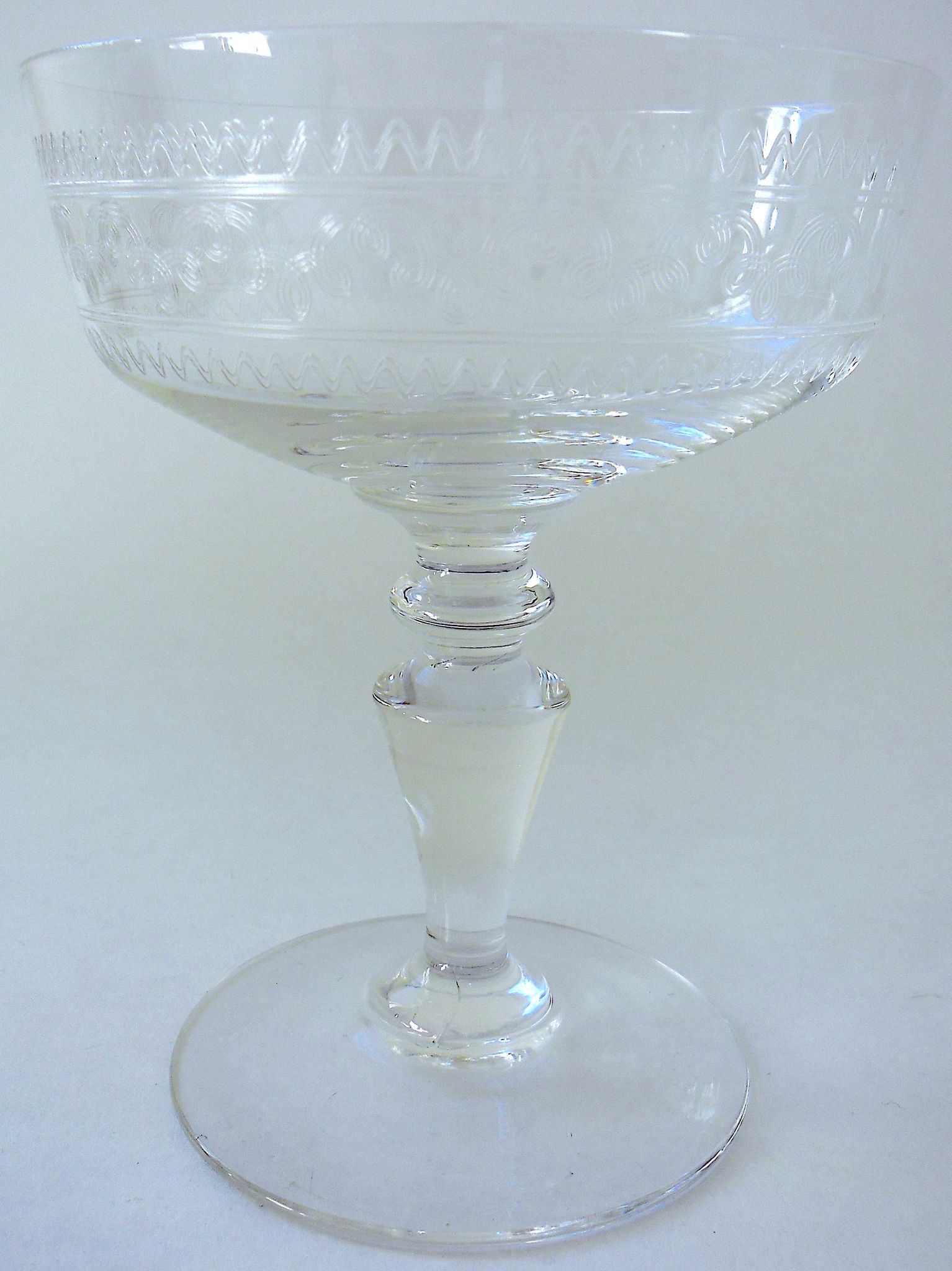 Suite of six champagne glasses on foot in engraved colorless crystal