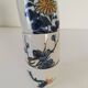 Set of three hand-painted porcelain cups with floral patterns.