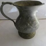 pewter pitcher with handle and bunch of grapes on the pot