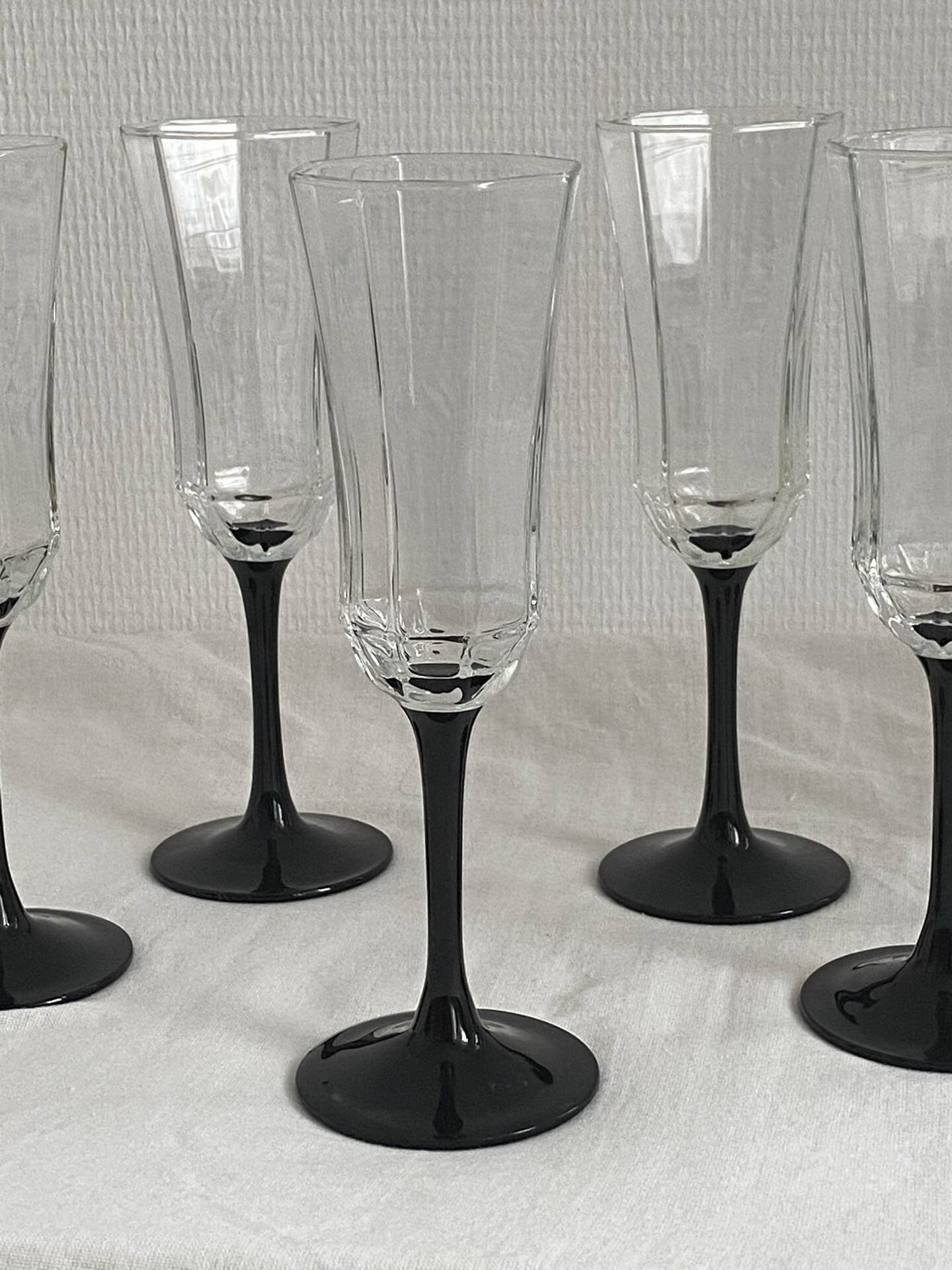 Set of 6 Octime champagne flutes in glass with black stem.