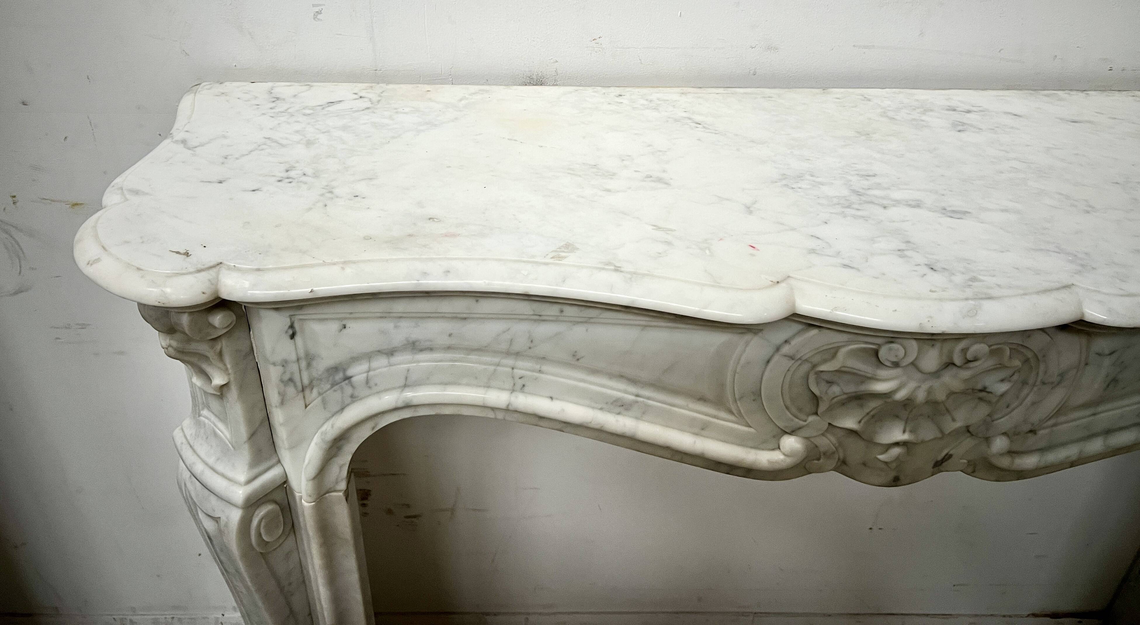 Louis XV style fireplace in veined white marble, 20th century.