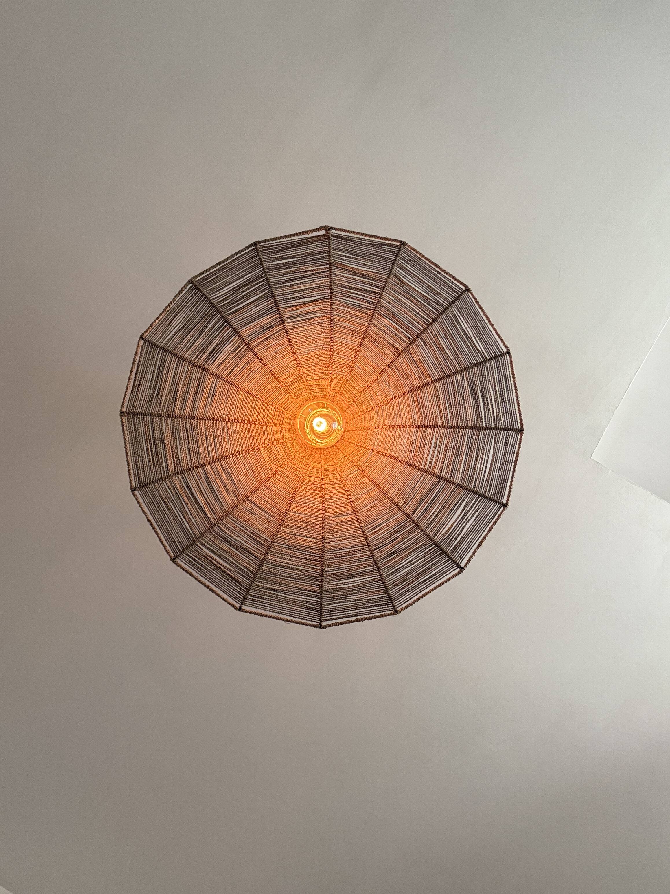 Large lampshade made of woven ropes.