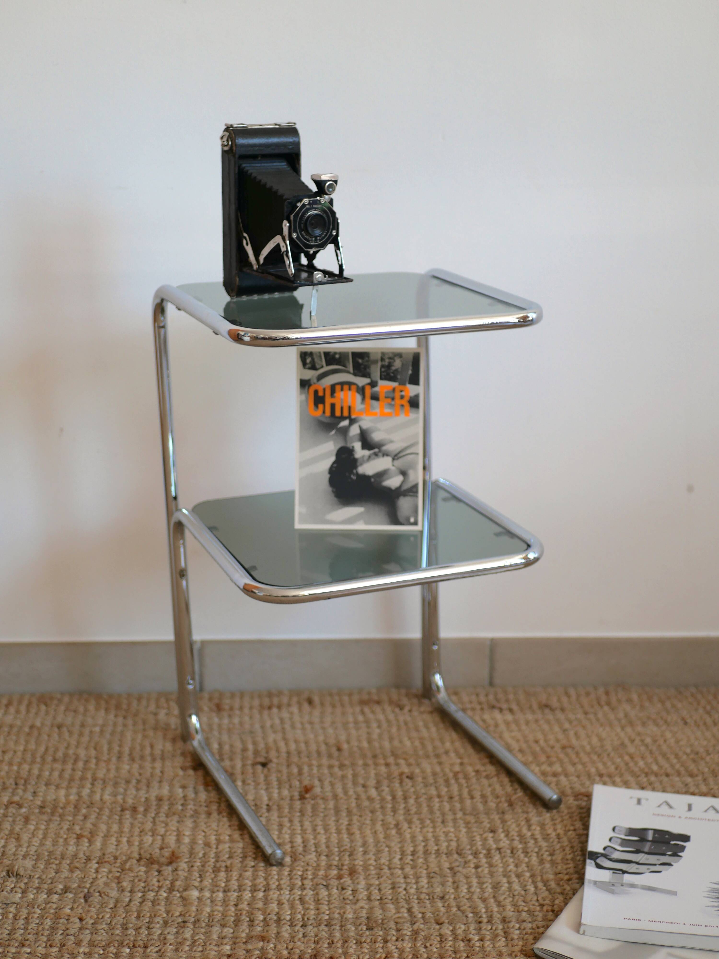 Glass-topped side table with tubular metal.