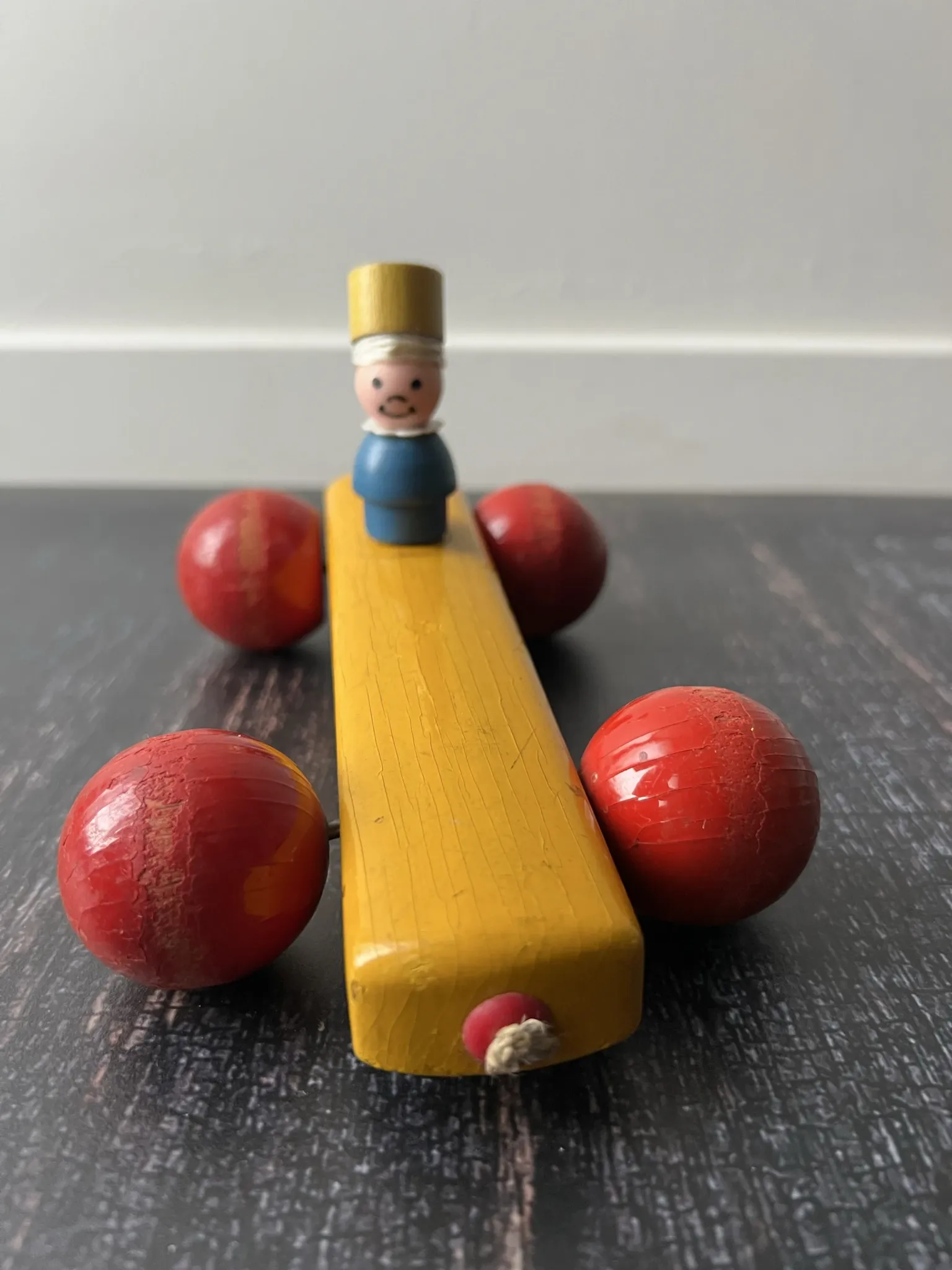 Vintage wooden pull toy, yellow car and small soldier.