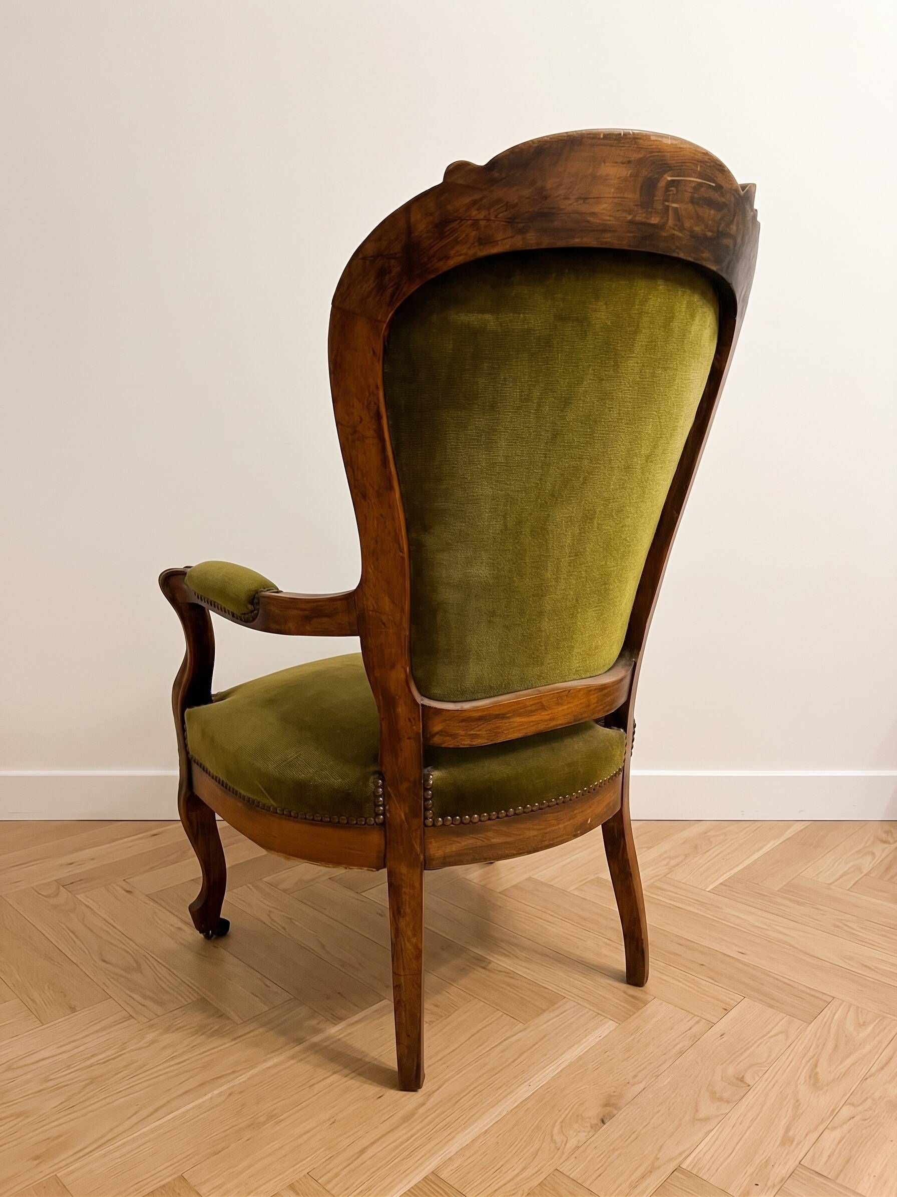 Antique armchair in olive green velvet and carved wood.