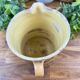 Large vintage ceramic pitcher with abstract green and brown decoration.
