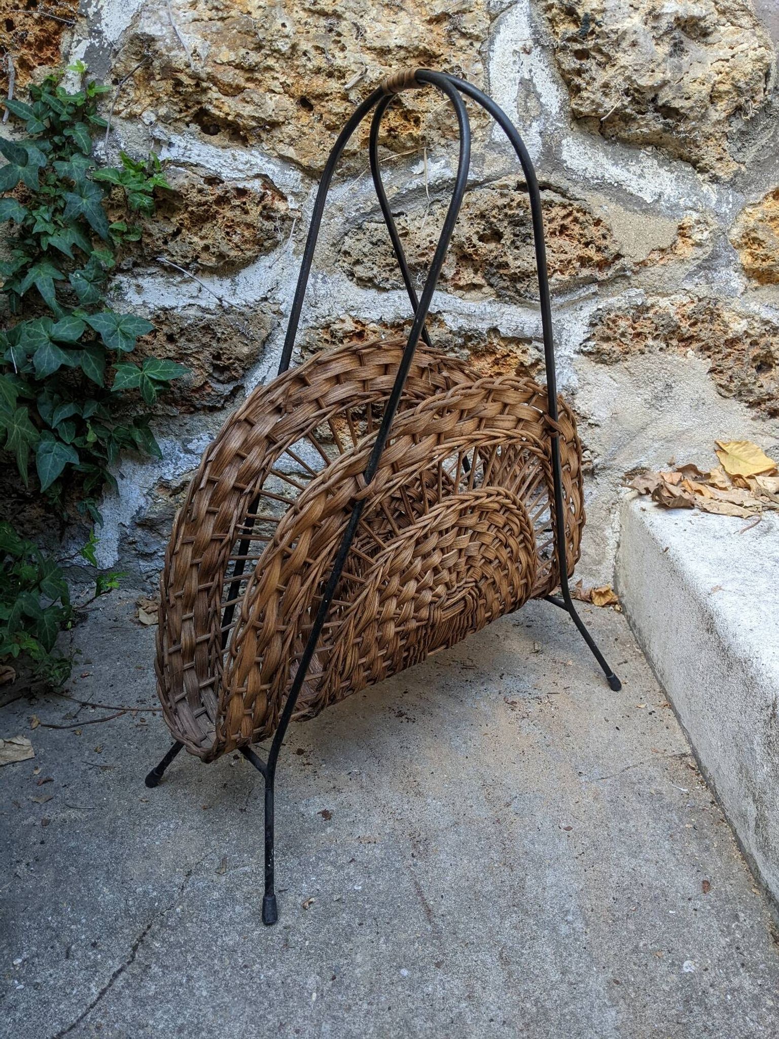 Vintage metal and wicker magazine rack, bohemian country decor.