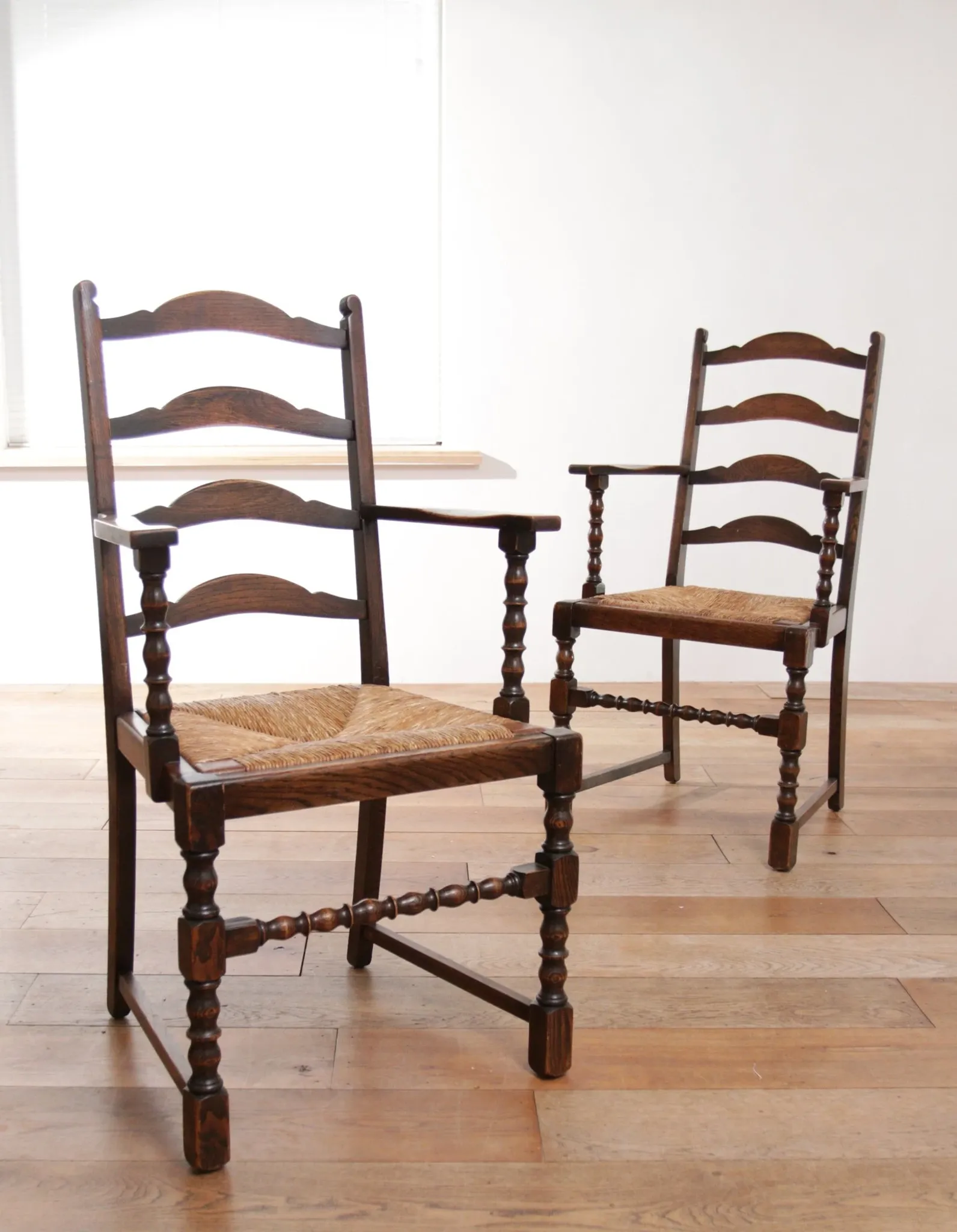 Pair of English oak armchairs with ladder back and rush seats