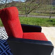 Pair of vintage armchairs in black faux leather and red fabric.