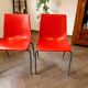 Pair of red plastic chairs with metal frame