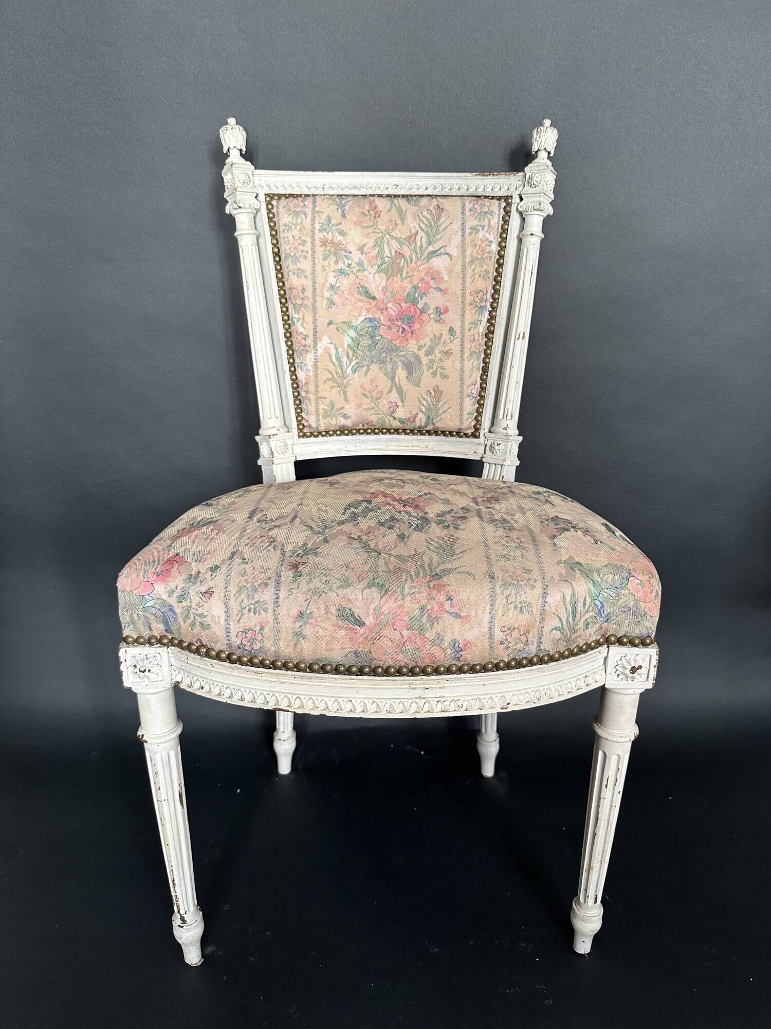 Antique Louis XVI style chair with patinated wood and floral fabric.