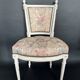 Antique Louis XVI style chair with patinated wood and floral fabric.