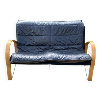 Black leather two-seater sofa with light wood armrests by Tord Bjorklund for Ikea, 1980s.