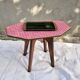 Small Scandinavian side table with wood and pink tiles, with tapered legs.