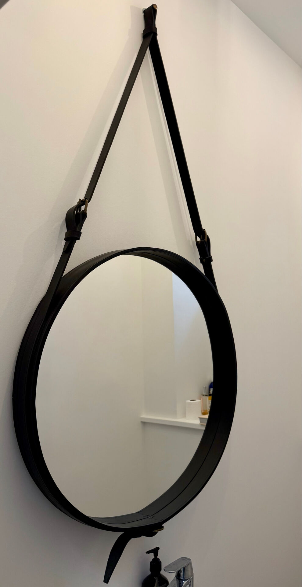 Round mirror covered in black leather in the style of Jacques Adnet.