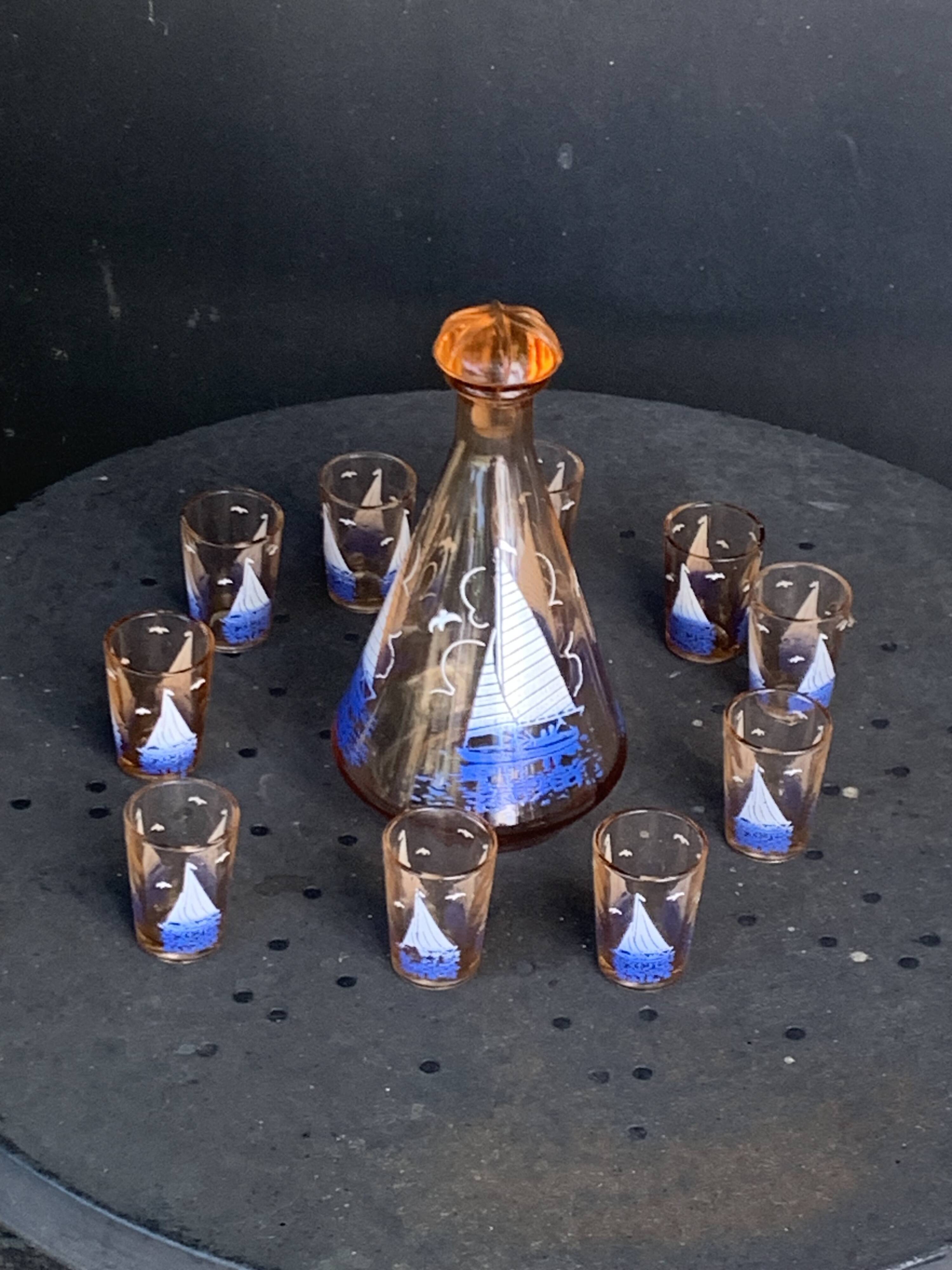 Service a liqueur, carafe en verre rose et 10 petits verres motif voilier