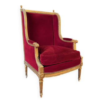 Golden wooden bergère in Louis XVI style upholstered in Bordeaux velvet.
