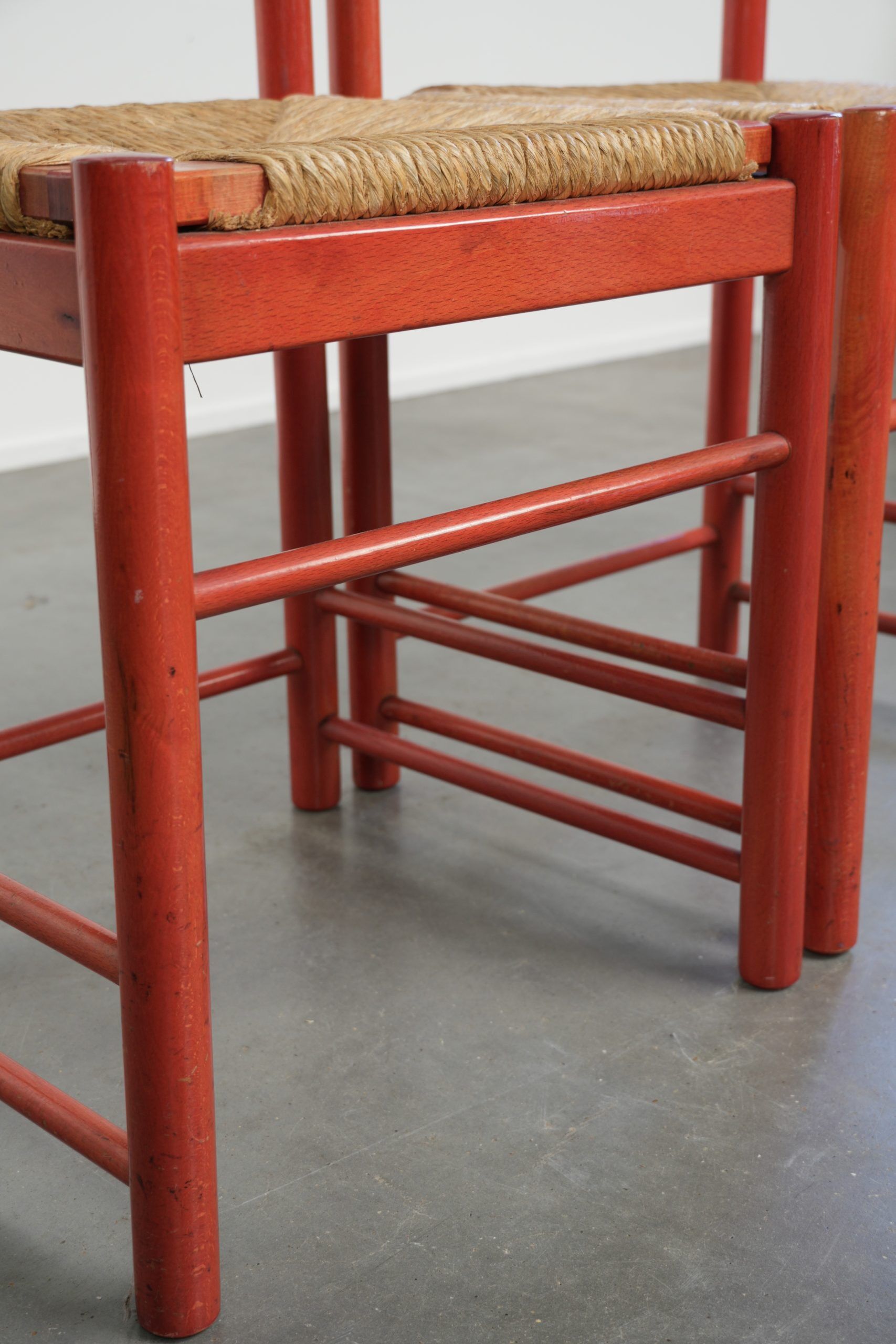 Set of two red vintage wooden chairs from the 1970s with woven rattan seats