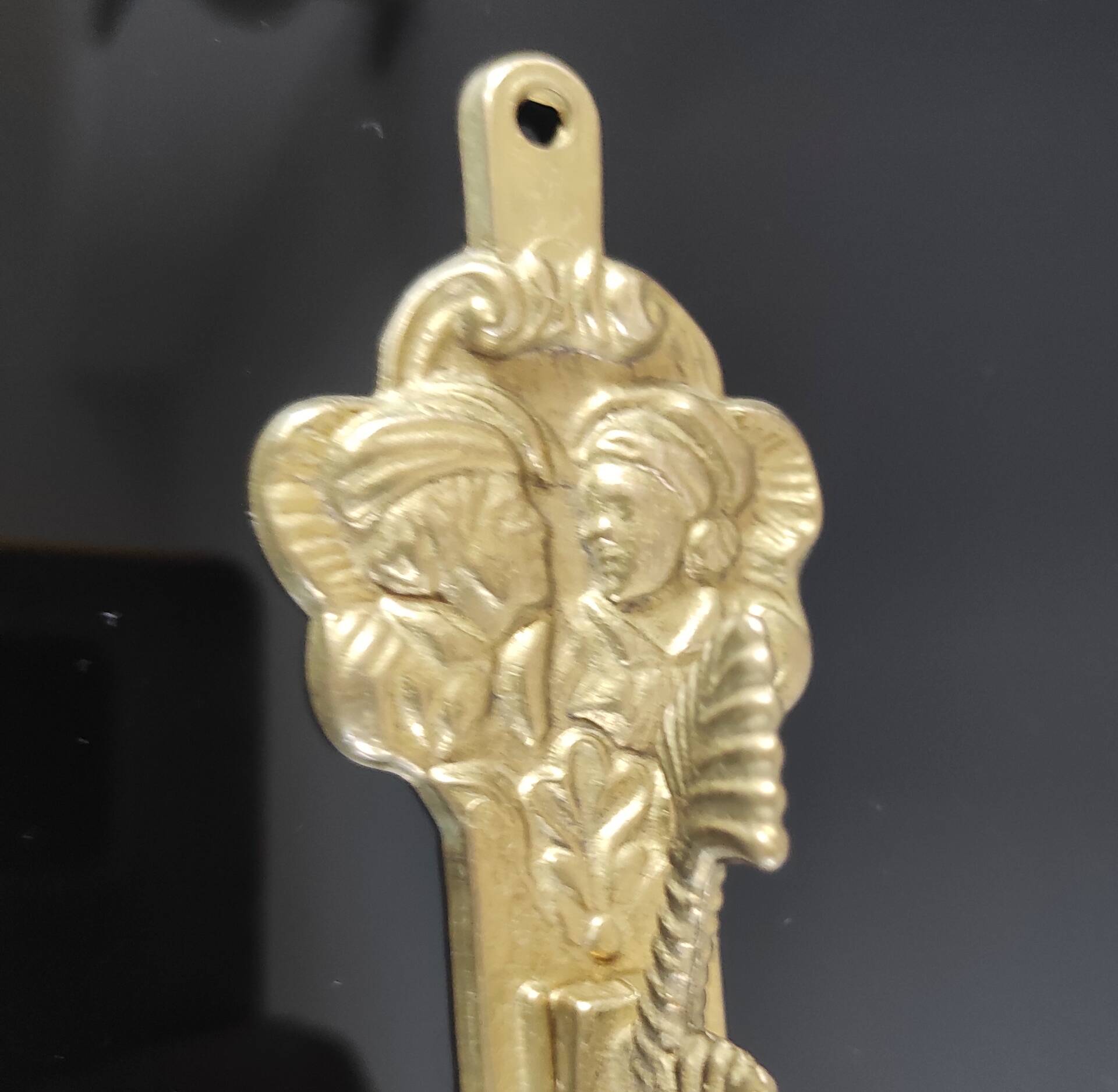 Vintage brass coat hook with marine creature motif and medallion.