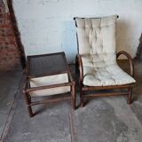 Relaxed armchair in bamboo and rattan with its small side table. Beige linen cushion.