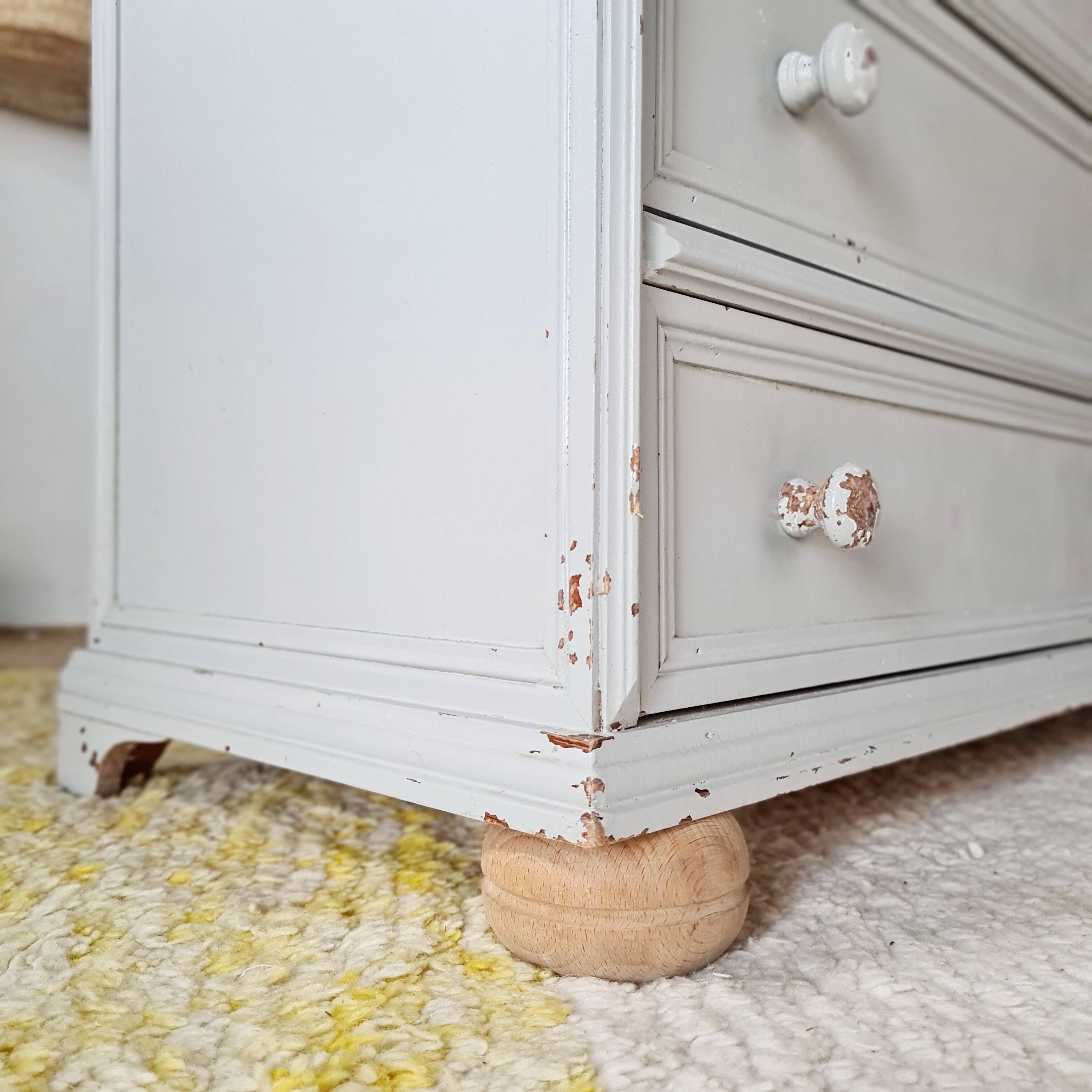 Commode ancienne à 4 tiroirs en bois peint gris perle patiné et pieds boules