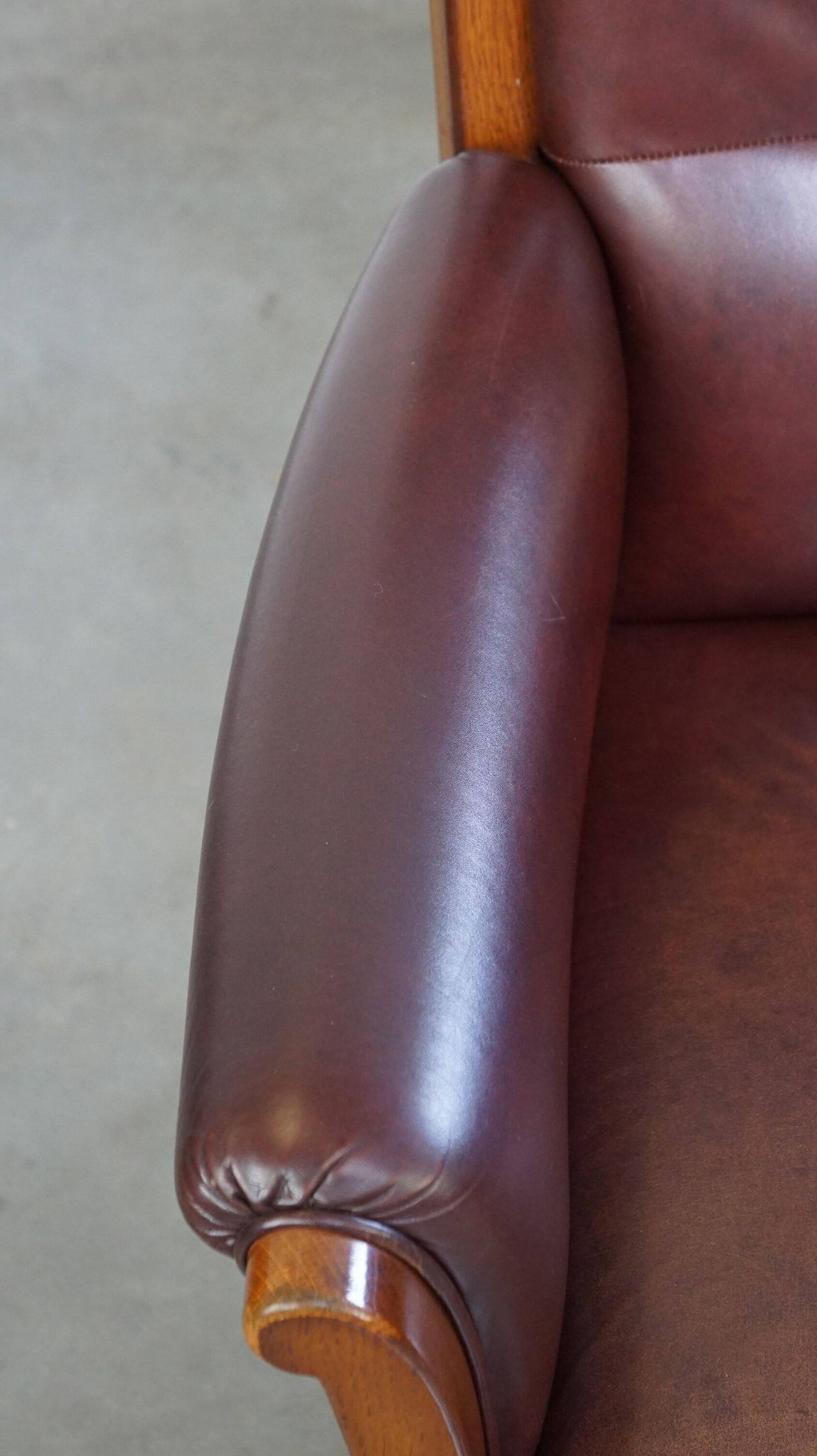 Very comfortable classic cowhide armchair with a high back in a mild Art Deco style