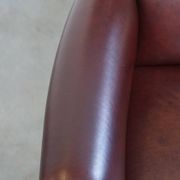 Very comfortable classic cowhide armchair with a high back in a mild Art Deco style